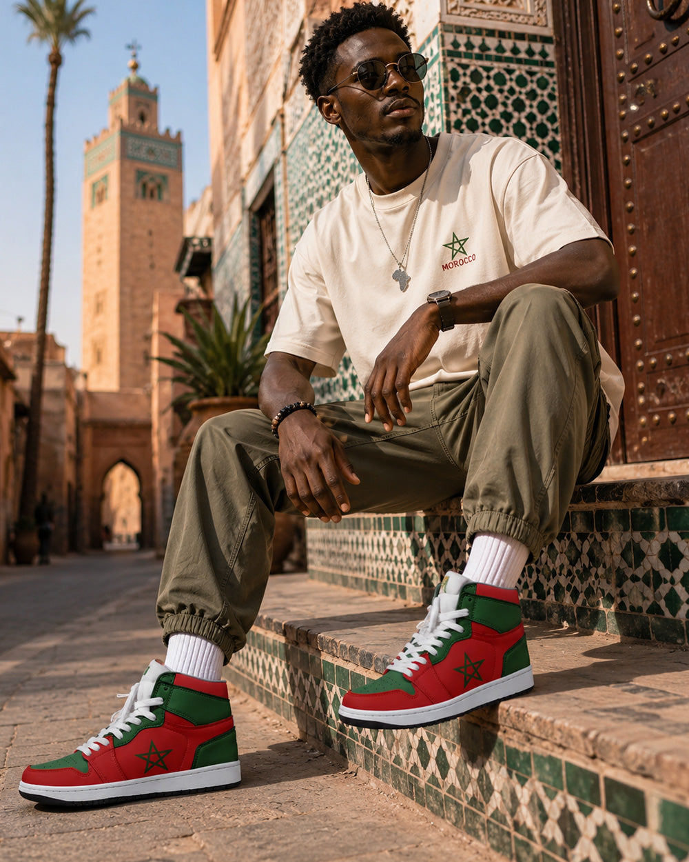 Man sitting on steps wearing red and green sneakers in a city setting