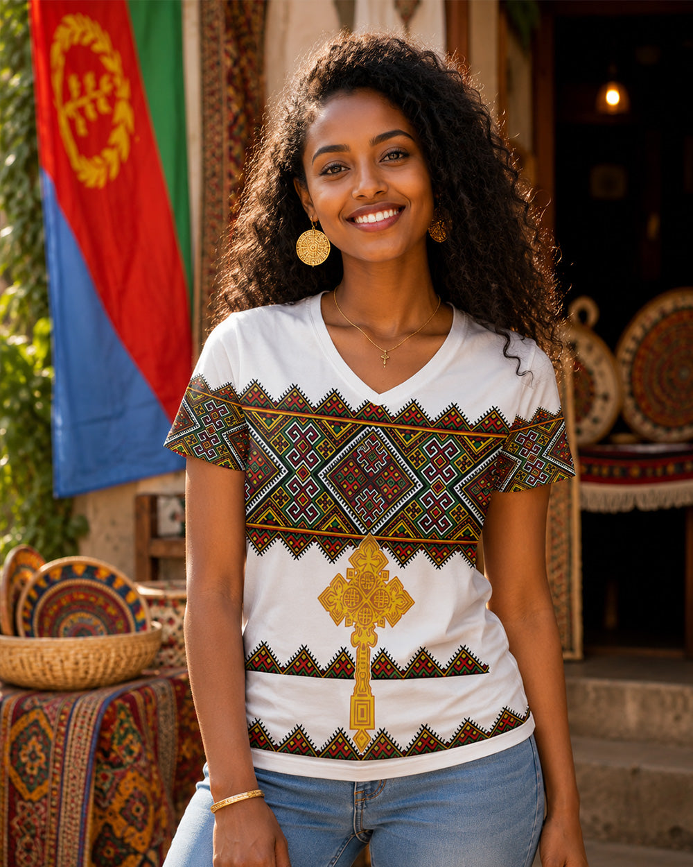 Woman wearing a white t-shirt with colorful patterns in an outdoor setting with flags in the background